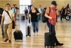  ?? Melissa Phillip / Houston Chronicle ?? New Yorker Brad Lukanic wears an Astros shirt and hat — after losing a bet with co-workers — as he waits for his flight Monday at Hobby Airport.