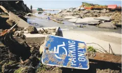  ??  ?? A disabled parking sign lies where part of the Stinson Beach lot washed into the ocean, eliminatin­g almost half of the lot’s 316 spaces.