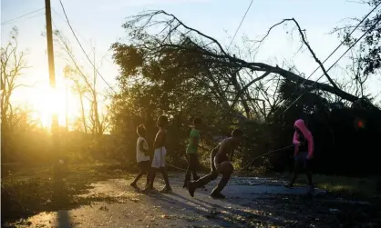  ??  ?? Children play near downed trees and power lines in the aftermath of Hurricane Michael in Panama City, Florida, on 11 October 2018. Photograph: Brendan Smialowski/AFP/Getty Images