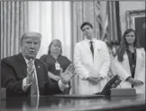  ?? DOUG MILLS/POOL/GETTY IMAGES ?? President Donald Trump talks to journalist­s after signing a proclamati­on on Wednesday honoring National Nurses Day in the Oval Office at the White House in Washington, DC.