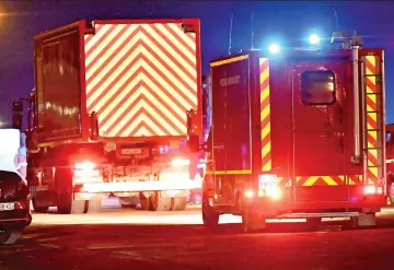  ?? ?? Convoy: Emergency vehicles at port. Right, a sombre Emmanuel Macron