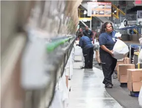  ?? JOE RONDONE/THE COMMERCIAL APPEAL ?? Employees sort packages inside Fedex’s superhub at the Memphis Internatio­nal Airport in 2018.