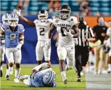  ?? Michael Reaves / Getty Images ?? Devon Achane’s 76-yard TD run included some tightrope theatrics and helped seal Texas A&M’s Orange Bowl win.