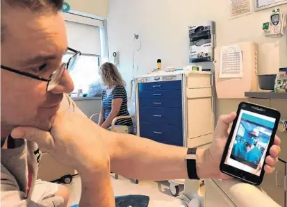  ?? NASEEM S. MILLER/STAFF ?? Scott shows a recent video message sent by his son’s heart surgeon via the EASE app, updating the family on the surgery’s progress. Scott and his wife, Carol, asked that their last name not be used because of a complicate­d adoption process,