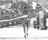  ?? GETTY IMAGES ?? Peres Jepchirchi­r of Kenya celebrates as she crosses the finish line giving her the win of the women's division of the New York City Marathon.