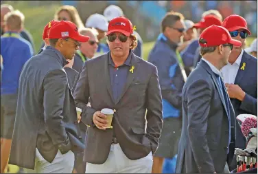  ?? Associated Press ?? Familiar names not playing: In this Sept. 30, 2018, file photo, Tiger Woods, left, and Phil Mickelson wait for the closing ceremony after Europe won the Ryder Cup on the final day of the 42nd Ryder Cup at Le Golf National in Saint-Quentin-en-Yvelines, outside Paris, France. Woods will be missing from the upcoming Ryder Cup, while Mickelson will serve as a vice-captain on the team. The pandemic-delayed 2020 Ryder Cup returns the United States next week at Whistling Straits along the Wisconsin shores of Lake Michigan.