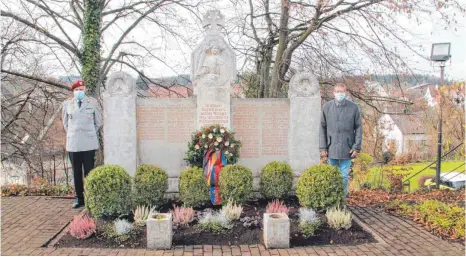  ?? FOTO: VERA ROMEU ?? Oberstabsf­eldwebel a. D. Georg Arnold und Scheers Bürgermeis­ter Lothar Fischer legen in aller Stille den Kranz der Bundeswehr am Denkmal für die Kriegsopfe­r in Heudorf nieder. Die Soldaten der 6. Batterie des Artillerie­bataillons 205 dürfen wegen der Corona-Pandemie am Volkstraue­rtag ihre Patengemei­nde nicht besuchen.