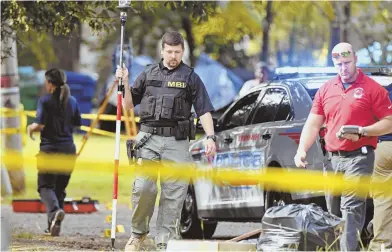  ?? AP PHOTOS ?? SHOOTING SCENE: Mississipp­i Bureau of Investigat­ion officers work the scene where two police officers were shot and killed in Brookhaven, Miss., yesterday.