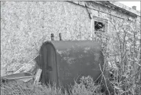  ??  ?? An old oil tank leans against a derelict shed in a backyard on Eleventh Street in Glace Bay. Residents say this has been ongoing for many years, with the owner unwilling to clean up the unsightly mess in his yard.