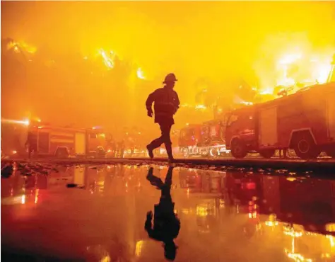  ?? — AFP ?? Firefighte­rs work at the scene of a fire at Kandawgyi Palace hotel in Yangon on Thursday.