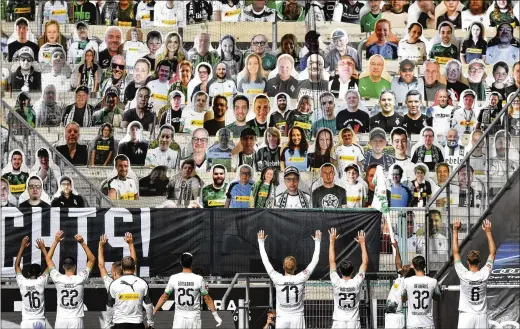  ?? MARTIN MEISSNER / ASSOCIATED PRESS ?? Players celebrate in front of cardboard photos of fans displayed in the stands at the German Bundesliga match between Borussia Moenchengl­adbach and Union Berlin last month. The Bundesliga was the world’s first major soccer league to resume after a two-month suspension because of the pandemic.