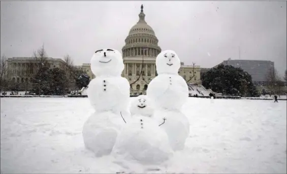  ?? ALEX BRANDON — THE ASSOCIATED PRESS ?? A snow family is seen on Capitol Hill as a winter storm arrives in the region, Sunday in Washington.