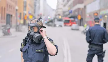  ?? FOTOS: REUTERS (2), AFP ?? Polizisten sperren kurz nach dem Anschlag die Einkaufsst­raße Drottningg­atan im Zentrum Stockholms.