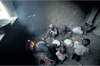  ?? ABDULMONAM EASSA/GETTY IMAGES ?? Syrians cook bread inside a school turned into a shelter for people displaced by the war, in the rebel-controlled town of Hamouria, in the eastern Ghouta region on the outskirts of the capital Damascus.