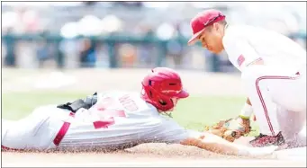  ?? ?? Arkansas Braydon Webb (24) slides to third base for a triple in the first inning as Stanford third baseman Drew Bowser fields the late throw on Saturday at the College World Series. (Photo by John Peterson, AP)