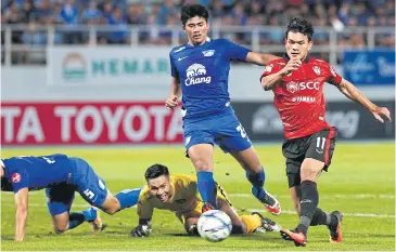  ??  ?? Muang Thong’s Adisak Kraisorn, right, scores his team’s opening goal against Chonburi.