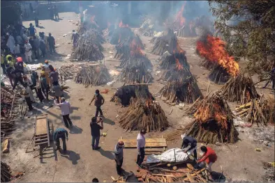  ?? Altaf Qadri / Associated Press ?? Multiple funeral pyres of victims of COVID-19 burn in an area that has been converted for mass cremation in New Delhi, India, on April 24.