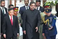  ?? AAMIR QURESHI / AFP ?? Vice-Premier Wang Yang and Pakistan’s Interim Prime Minister Shahid Khaqan Abbasi (center) arrive at a flag ceremony in Islamabad for Independen­ce Day on Monday.