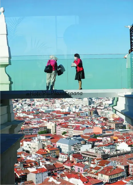  ?? GONZALO PÉREZ ?? Turistas toman fotos desde la pasarela de cristal del Hotel Riu Plaza de España