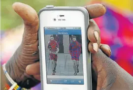  ?? Picture: REUTERS ?? RIGHT IDEA: A Maasai artisan looks at an image of models in creations by French fashion house Louis Vuitton as she prepares Maasai garments in Ngong, Kenya