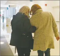  ?? (AP/Martha Irvine) ?? Janine Blezien (left) and Green walk arm-in-arm at Rush University Medical Center in Chicago during their first in-person meeting. Blezien, a nurse at Rush, and Green, a retiree, met by phone the previous year through the hospital’s “friendly caller” program.