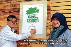  ??  ?? MOHAMAD Roff menandatan­gani Goat 2 Go Animal Garden sambil diperhatik­an Kamariah.