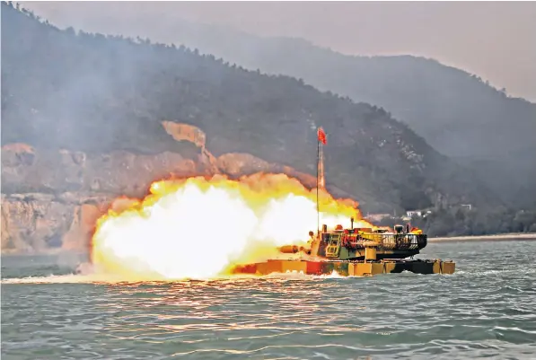  ??  ?? A Type-05 advanced amphibious assault vehicle attached to a brigade under the PLA 74th Group Army fires at simulated sea targets during the maritime live-fire training exercise in waters near Taiwan