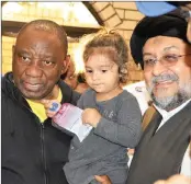  ?? PICTURE: TUMI PAKKIES / AFRICAN NEWS AGENCY (ANA) ?? President Cyril Ramaphosa carries the child of slain Abbas Essop while Moulana Syed Aftab Haider looks on.