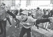  ?? AP PHOTO ?? A fan of Uruguay’s national soccer team reacts in downtown Montevideo, Uruguay, after Jose Gimenez scores the winning goal during a televised broadcast of the 2018 World Cup match between Egypt and Uruguay.