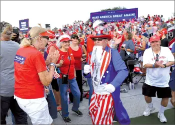  ??  ?? Supporters of Trump dance as they await his arrival for a campaign rally at The Villages Polo Club in The Villages, Florida.