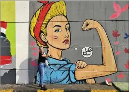  ?? KHALID MOHAMMED — THE ASSOCIATED PRESS ?? A woman poses in front of graffiti at the Saadoun tunnel, in Baghdad, Iraq.