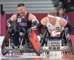  ?? SHUJI KAJIYAMA/AP ?? Britain’s Aaron Phipps, right, moves the ball against Joshua Wheeler of the United States during the wheelchair rugby gold medal match at the Tokyo 2020 Paralympic Games on Sunday in Tokyo.