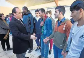  ?? JEAN-SEBASTIEN EVRARD/GETTY-AFP ?? François Hollande meets migrants Saturday during a trip to Doue-la-Fontaine, France.