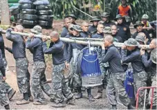 ??  ?? Militares cargan una bomba para drenar el agua en la cueva de Tham Luang Nang, donde se intenta el rescate de 12 niños y su entrenador.