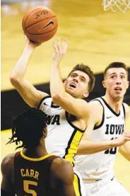  ?? MATTHEW HOLST GETTY IMAGES ?? Iowa’s Jordan Bohannon, who had 19 points and 14 assists, shoots over Minnesota’s Marcus Carr.