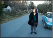  ?? NWA Democrat-Gazette/ANDY SHUPE ?? Sarah Marsh, Fayettevil­le City Council member, uses a tape measure Wednesday to measure the width of Oliver Avenue in Fayettevil­le to better understand options to improve the street and make it more walkable.