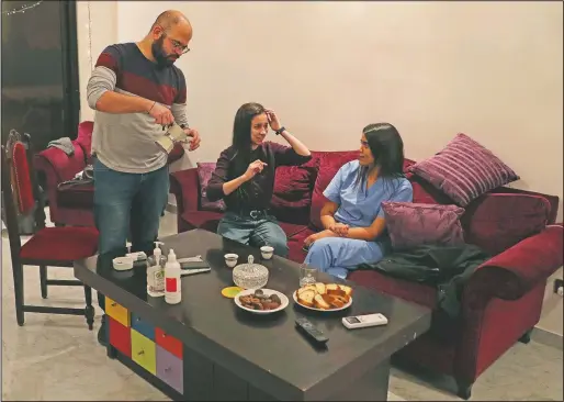  ?? (AP/Bilal Hussein) ?? Issa Tannous (from left), internal medicine resident; Nour Kassem, medical intern; and Chloe Ghosh, neurology resident, drink coffee at a temporary apartment provided by Lebanese NGO Baytna Baytak for medical frontline workers in Beirut.