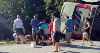  ?? (foto da Twitter) ?? Fuori strada Il bus sul ciglio della strada mentre alcuni turisti ricevono i primi soccorsi dai sopravviss­uti