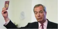  ?? NIKLAS HALLE’N/AFP/GETTY IMAGES ?? U.K. Independen­ce Party Leader Nigel Farage holds the current burgundy British passport.