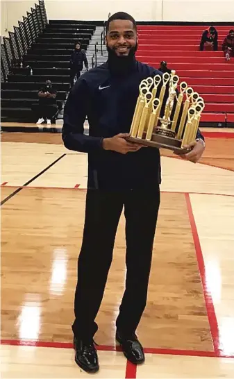  ?? JAMERE DISMUKES ?? Jamere Dismukes, then the coach at Hyde Park, poses with the 2021 Big Dipper Holiday Tournament championsh­ip trophy. Dismukes is now the coach at Rich and vows to return the Big Dipper to prominence.