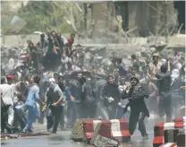  ?? MASSOUD HOSSAINI/THE ASSOCIATED PRESS ?? Protesters throw stones toward security forces Friday during a demonstrat­ion in Kabul, Afghanista­n. Hundreds of demonstrat­ors demanded better security in the Afghan capital in the wake of a powerful truck bomb attack that killed scores of people.