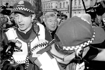  ?? — AFP photo ?? Pell (centre) arrives under heavy police protection for a hearing at the Melbourne Magistrate­s Court in Melbourne.