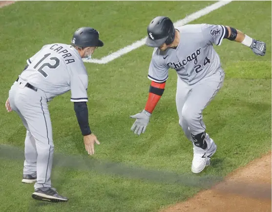  ?? KAMIL KRZACZYNSK­I/AP ?? Yasmani Grandal celebrates with third-base coach Nick Capra after hitting a two-run home run off Jon Lester in the fourth inning Friday night.