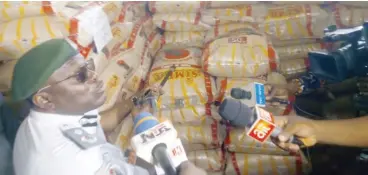  ?? ?? Acting Controller of Federal Operations Unit (FOU), Zone A, Ikeja, Hussein Kehinde Ejibunu, showcasing the poisonous bags of Simba rice that were seized from smugglers
