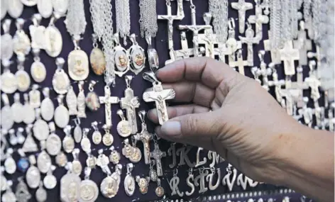  ?? FOTO: AGENCIAUNO ?? ►► Detalle de crucifijos en venta fuera de una iglesia en Santiago.