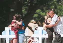  ?? ?? DOLOR. Familiares de los fallecidos se abrazan en un monumento en la plaza del pueblo para las víctimas del tiroteo en Uvalde.