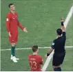  ?? DARKO BANDIC THE ASSOCIATED PRESS ?? Enrique Caceres gives a yellow card to Portugal’s Cristiano Ronaldo.