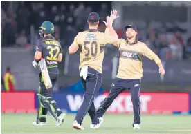  ?? Photo / Getty Images ?? Jimmy Neesham and Devon Conway celebrate a wicket.