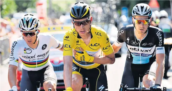  ??  ?? Germany’s Tony Martin, wearing the overall leader’s yellow jersey, is helped to the line by his teammates after breaking his collarbone in a crash.