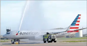  ?? Photo by Mike Eckels ?? Two units from the Northwest Arkansas Regional Airport fire department shoot an arch of water over the chartered aircraft of the O&A Honor Flight as it taxied to runway 16 April 19 in Highfill. The arch is a time-honored tradition paying tribute to...